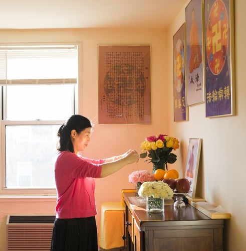 Wang Huijuan iskazuje poštovanje osnivaču Falun Gonga u svojoj kući u Queensu, u Njujorku, 8. januara 2016. godine. Sa svojim suprugom i kćerkom, pobjegla je iz Kine 2014. godine i dobila je azil nakon godina mučenja zbog prakticiranja Falun Gonga. (Samira Bouaou / Epoch Times)