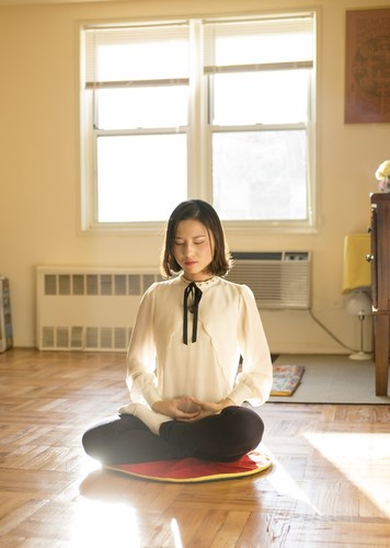 Li Fuyao demonstrira svoju meditativnu praksu u svojoj kući u Queensu, u Njujorku, 8. januara 2016. godine. Ona i njeni roditelji pobjegli su iz Kine 2014. godine i dobili su azil nakon godina mučenja zbog prakticiranja Falun Gonga. (Samira Bouaou / Epoch Times)